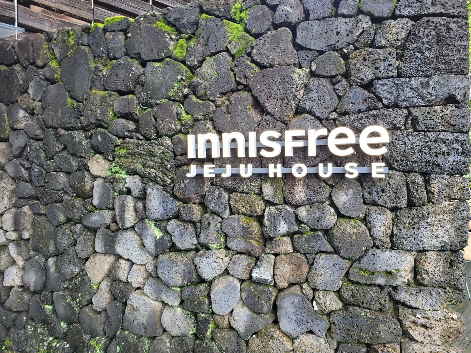 현무암 돌담의 INNISFREE JEJU HOUSE 사인