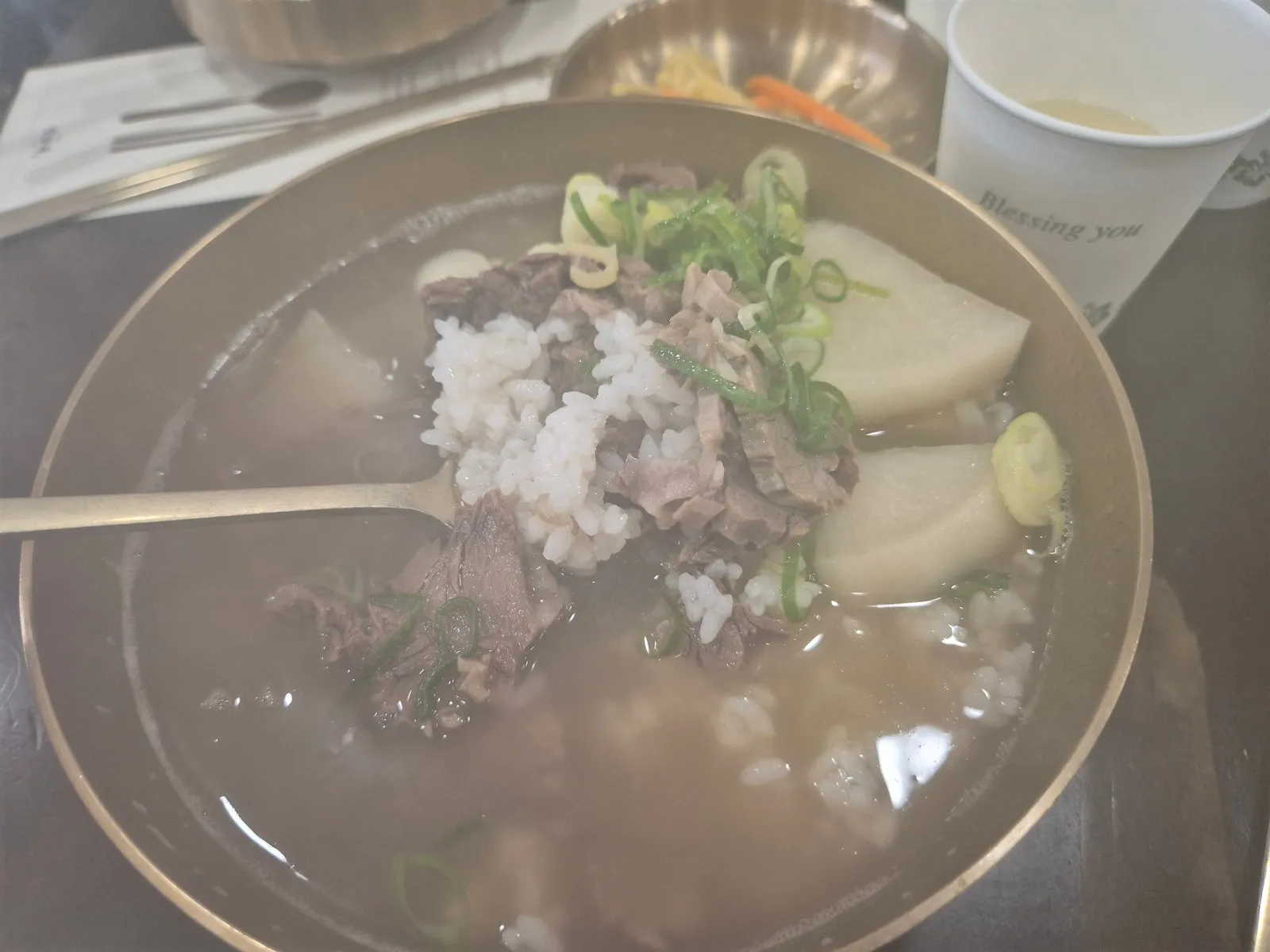 놋그릇에 담긴 한우뭇국 — 밥을 말아 무와 고기가 올라온 모습