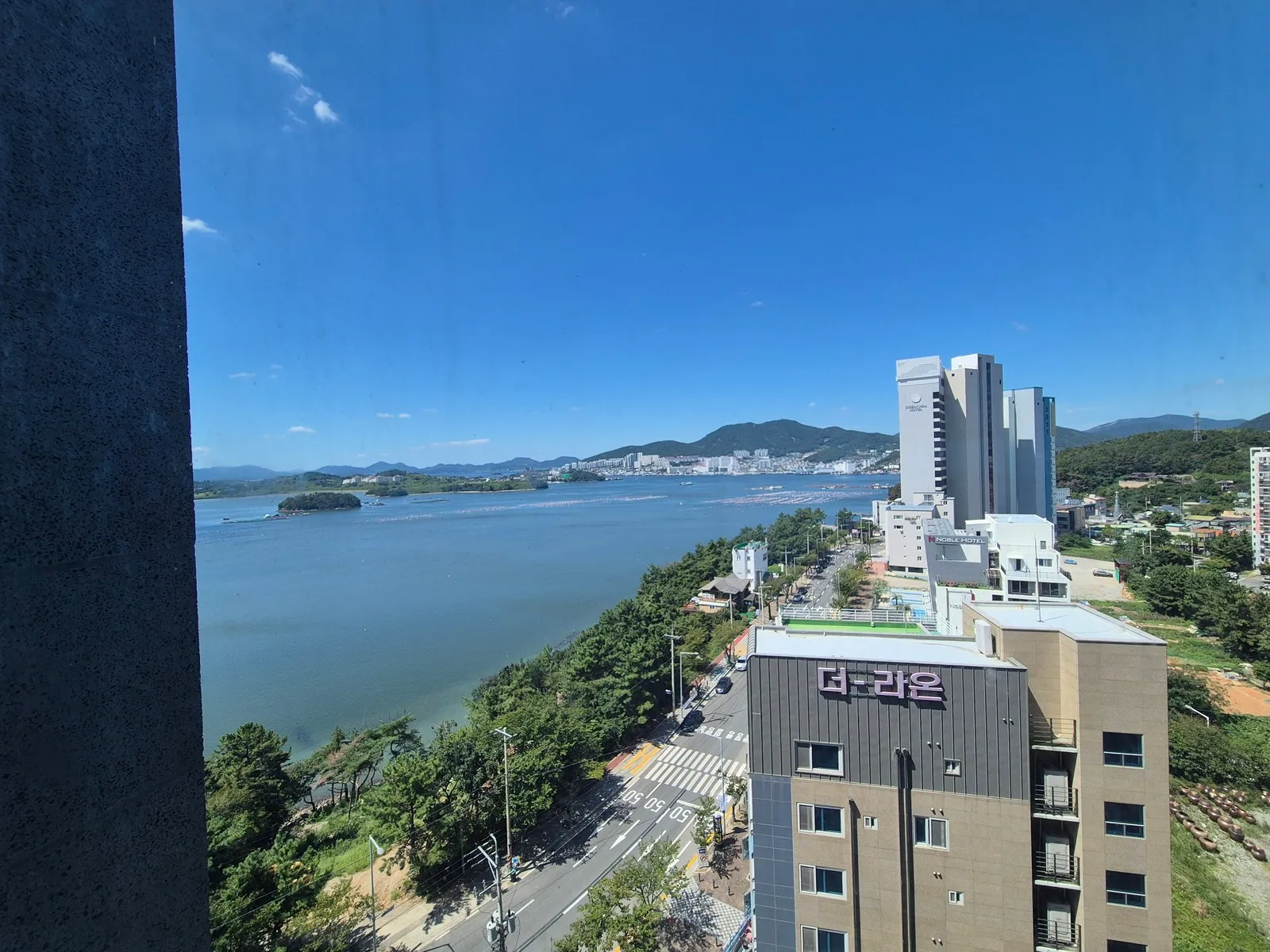 정오, 고층 창에서 본 만과 해안도로